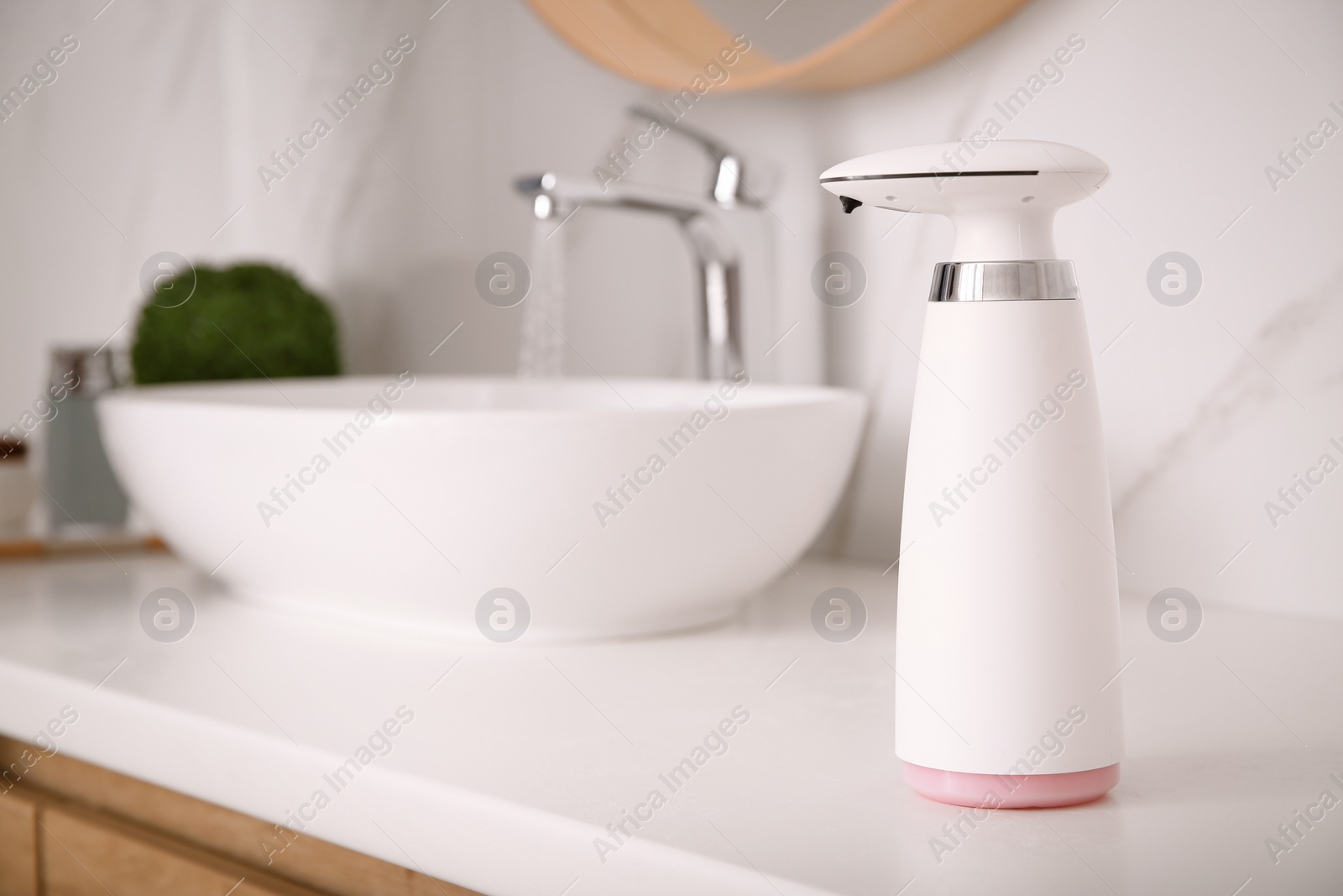 Photo of Modern automatic soap dispenser on countertop in bathroom. Space for text