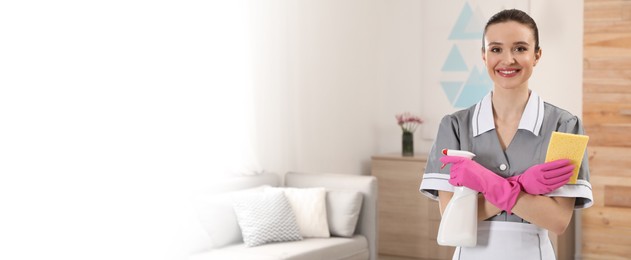 Image of Portrait of young chambermaid with cleaning supplies in hotel room, space for text. Banner design