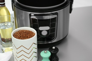 Photo of Modern multi cooker and ingredients on table, space for text