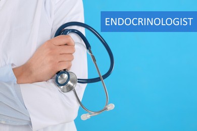 Endocrinologist with stethoscope on light blue background, closeup