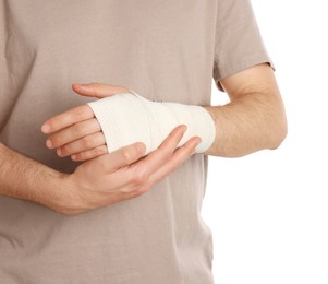 Photo of Man with hand wrapped in medical bandage on white background, closeup