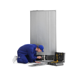 Male technician repairing refrigerator on white background