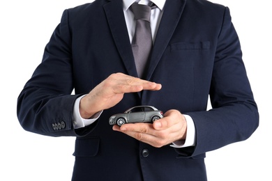 Photo of Male insurance agent holding toy car on white background, closeup