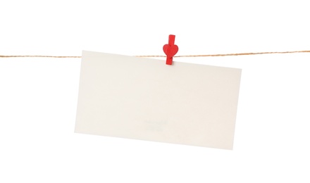 Blank card hanging on twine against white background. Valentine's Day celebration