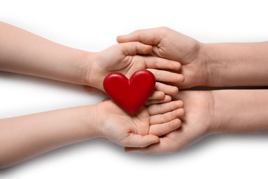 Woman and kid holding red heart in hands on white background, top view