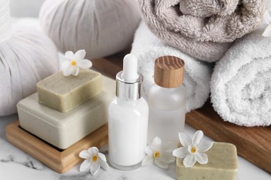 Composition with spa supplies and flowers on white marble table