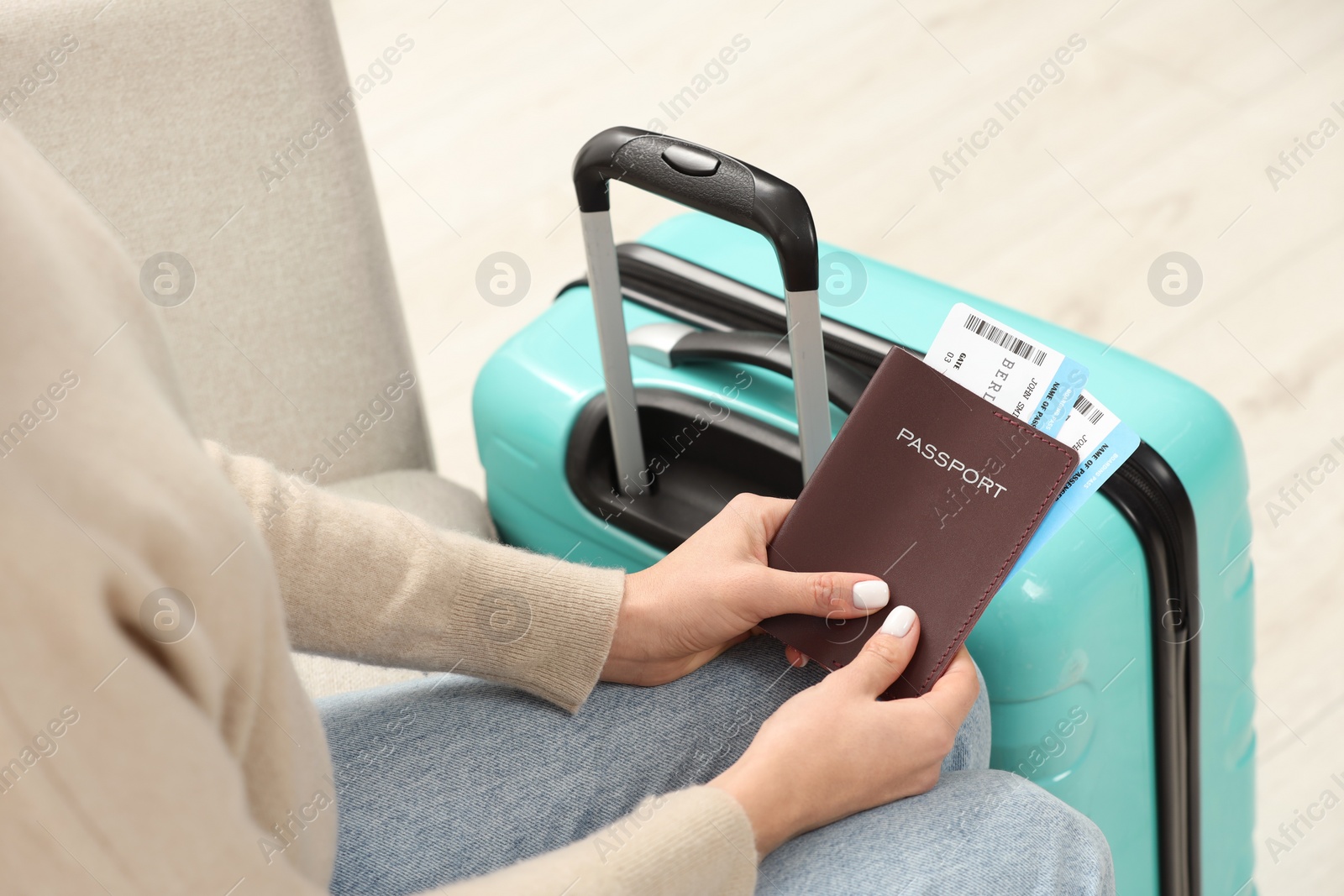 Photo of Woman with suitcase, passport and tickets on blurred background, closeup