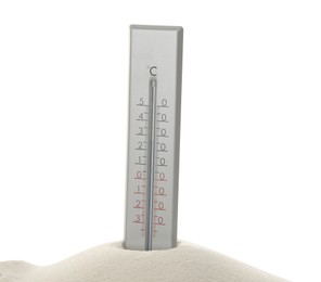 Weather thermometer in sand against white background