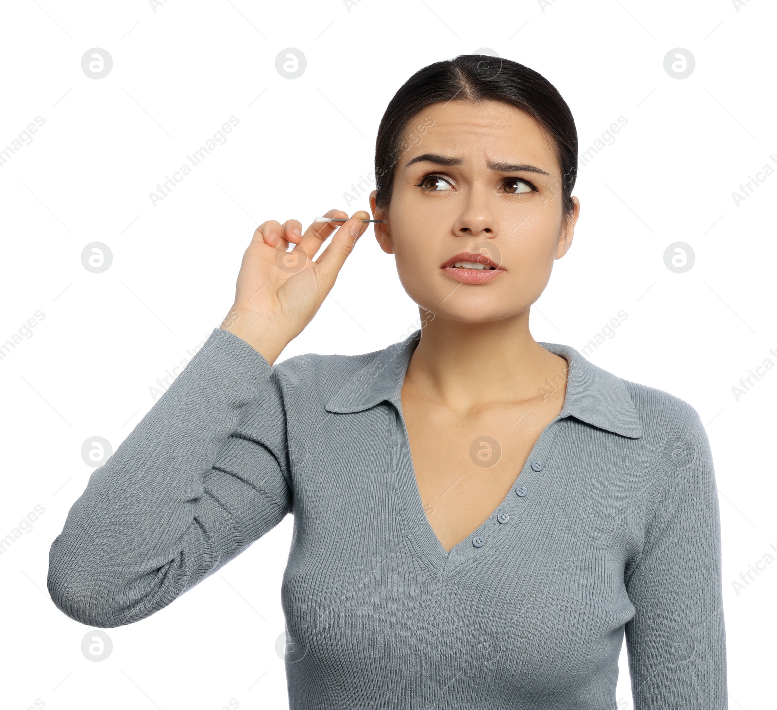 Photo of Young woman cleaning ear with cotton swab on white background