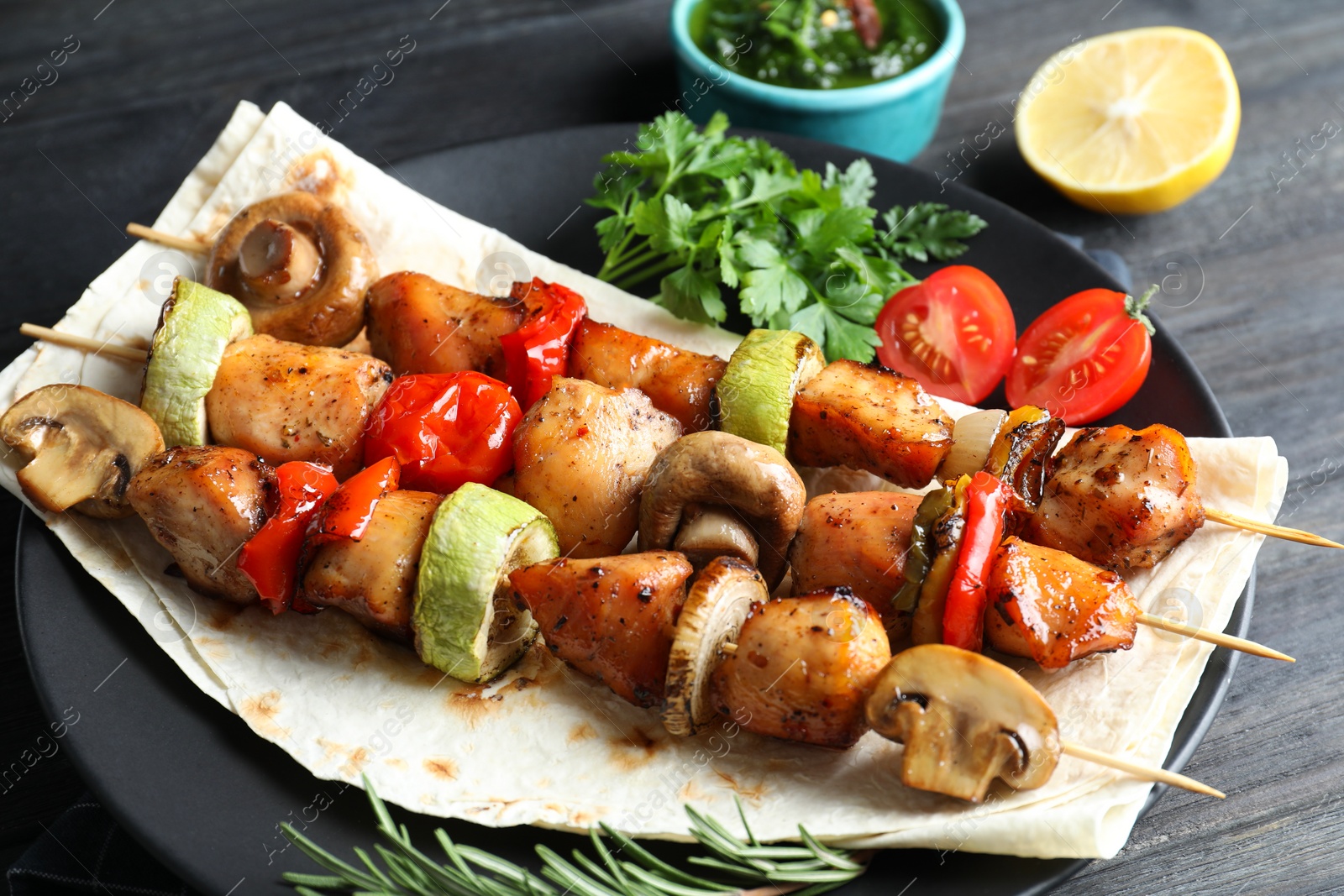 Photo of Delicious shish kebabs with vegetables served on table, closeup