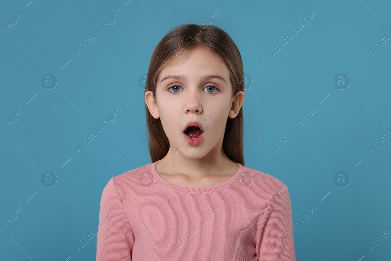 Photo of Portrait of surprised girl on light blue background