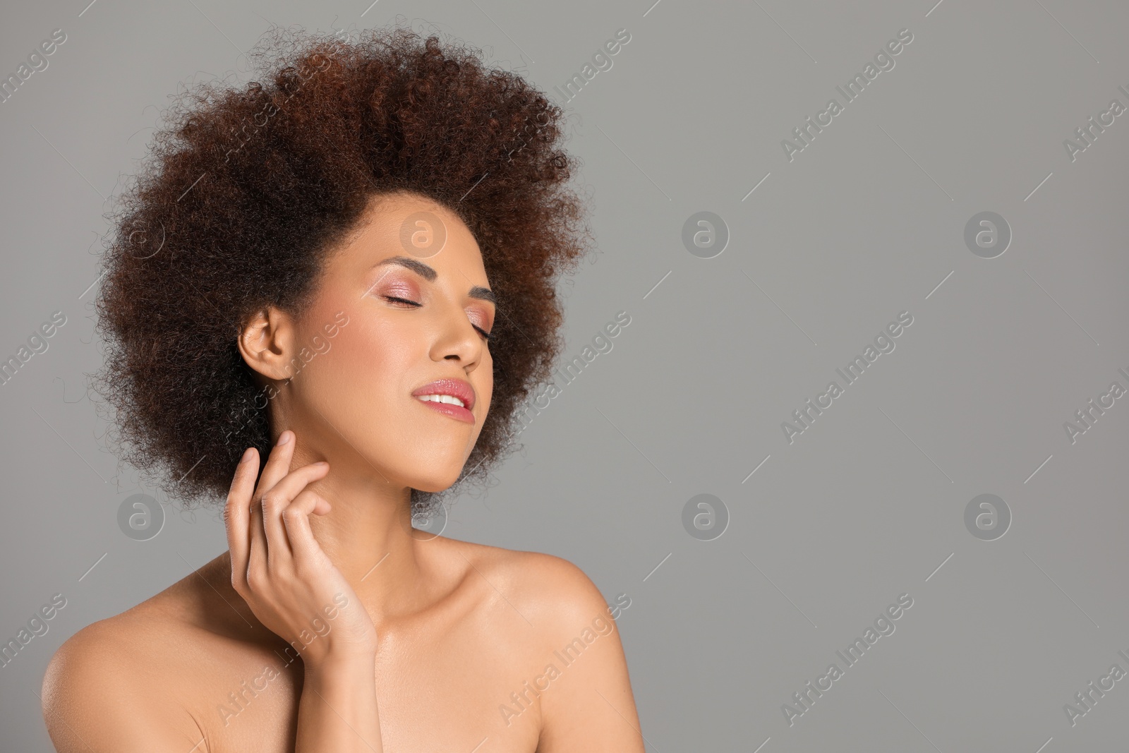 Photo of Portrait of beautiful young woman with glamorous makeup on grey background. Space for text