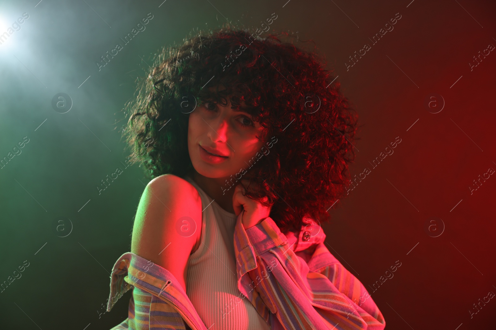 Photo of Beautiful young woman posing on color background in neon lights