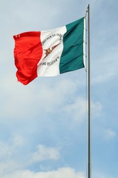 Photo of Mexico flag fluttering against blue sky on sunny day