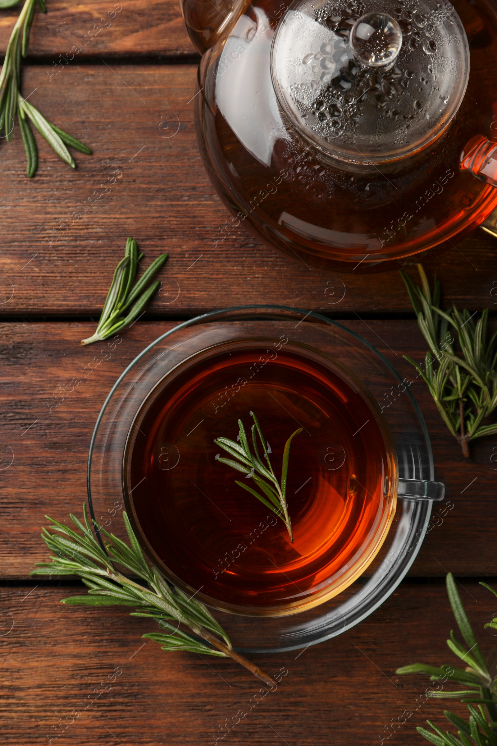 Photo of Aromatic herbal tea with rosemary on wooden table, flat lay