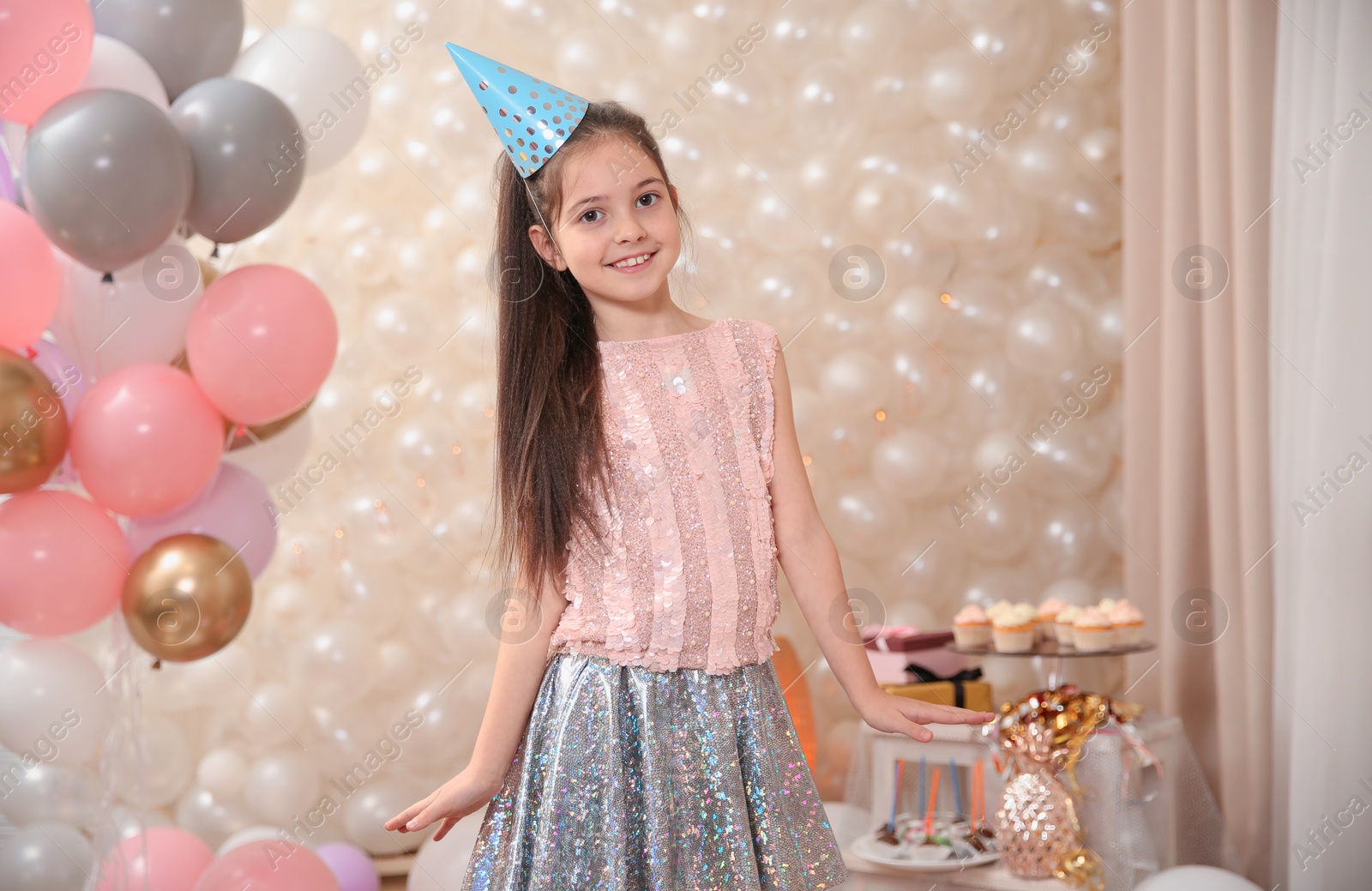 Photo of Happy little girl in beautifully decorated room at home. Birthday celebration