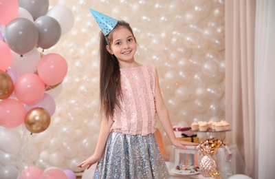 Happy little girl in beautifully decorated room at home. Birthday celebration