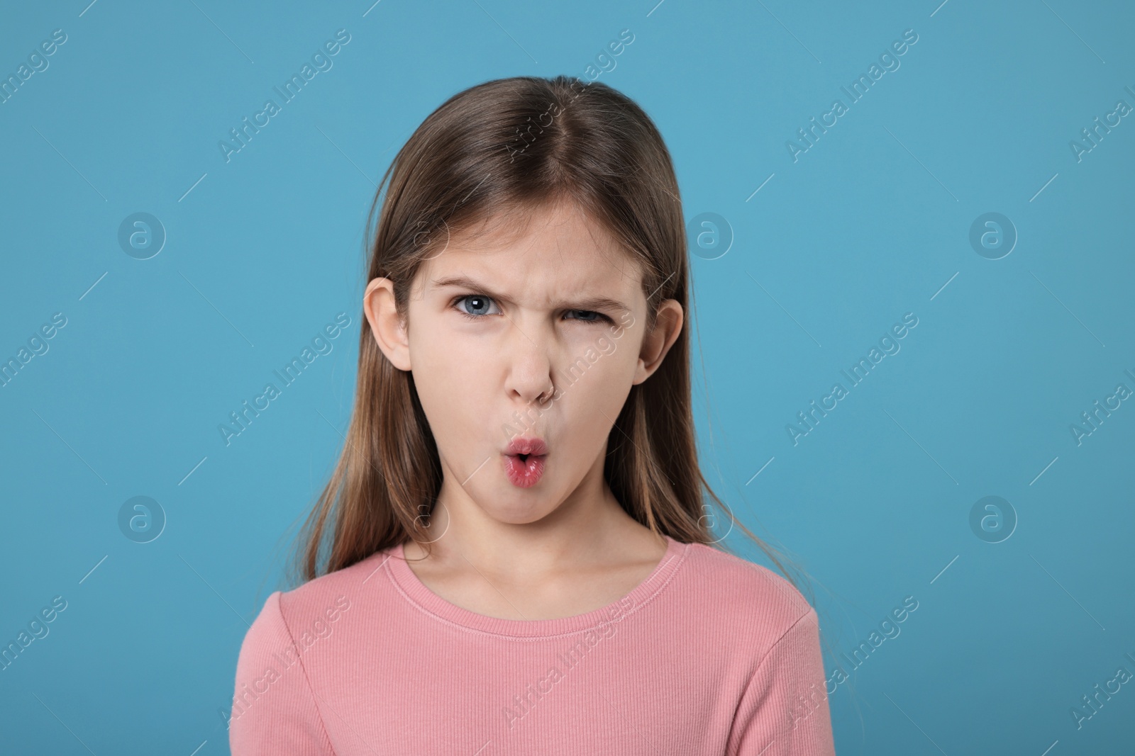 Photo of Portrait of surprised girl on light blue background