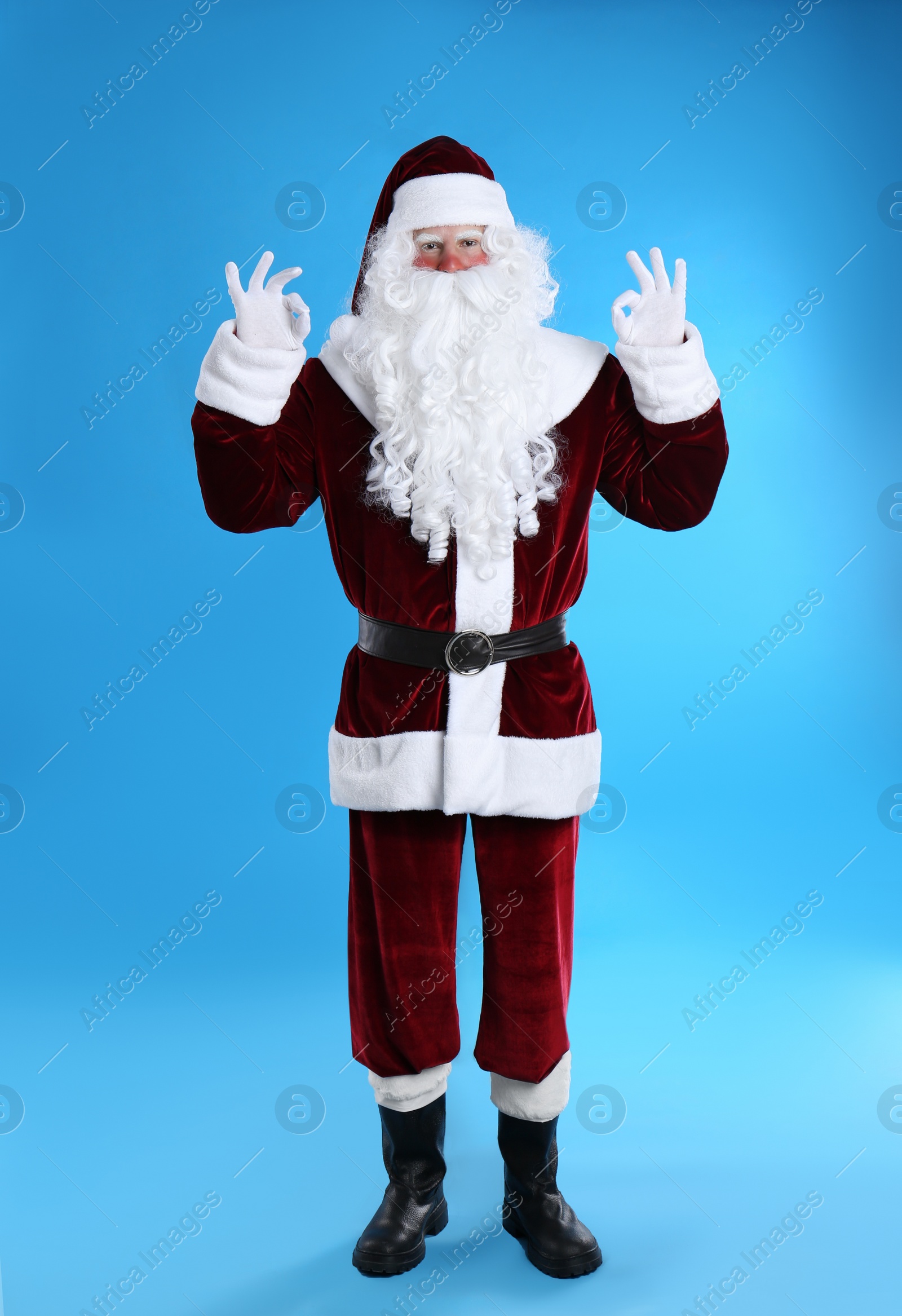 Photo of Full length portrait of Santa Claus on light blue background