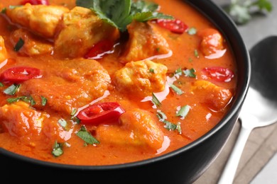 Bowl of delicious chicken curry on table, closeup