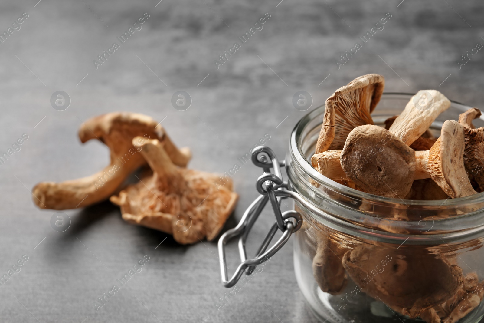 Photo of Composition of dried mushrooms and glass jar on table, closeup. Space for text