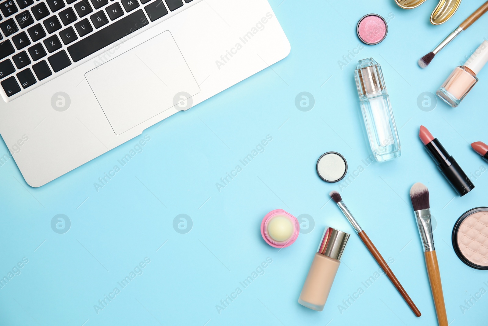 Photo of Flat lay composition with laptop and makeup products for woman on color background