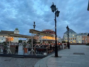 Photo of WARSAW, POLAND - JULY 15, 2022: Crowded Old Town Market Place and outdoor cafe terraces in evening