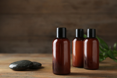 Cosmetic products and spa stones on wooden table