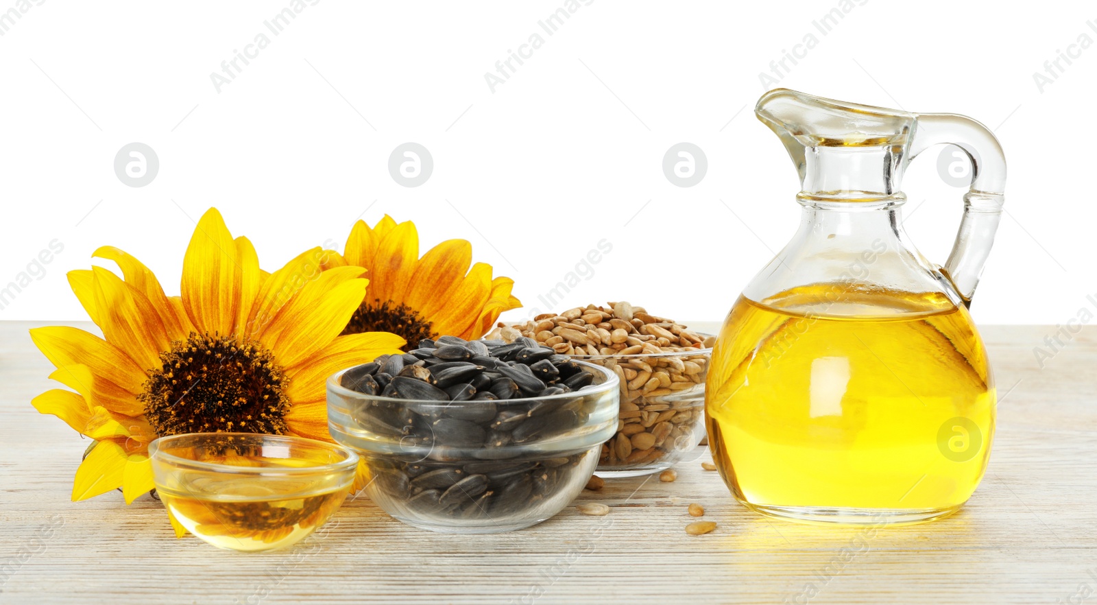 Photo of Composition with sunflower oil on wooden table against white background