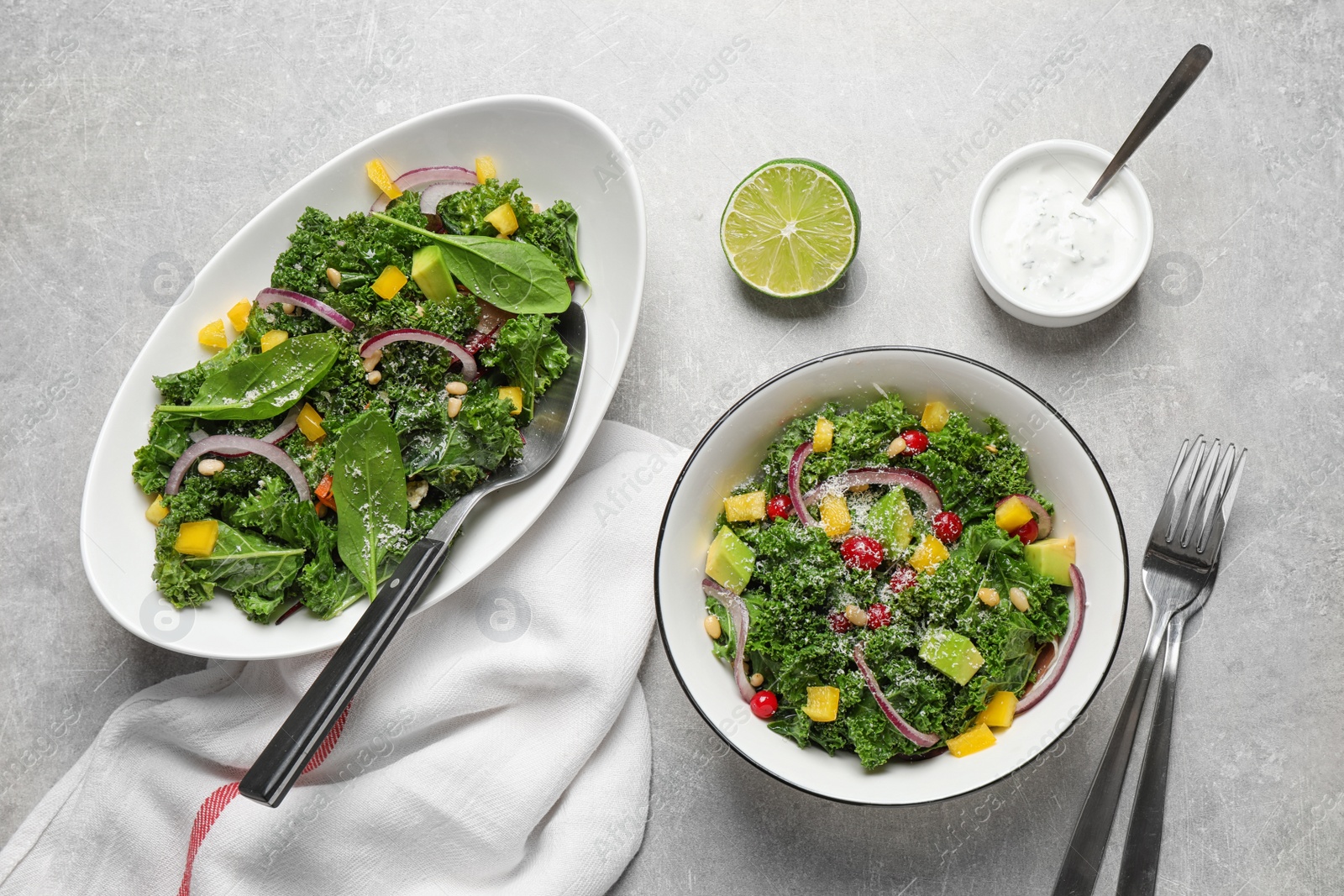 Photo of Tasty fresh kale salad on light grey table, flat lay