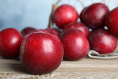 Photo of Delicious ripe plums on wooden table, closeup