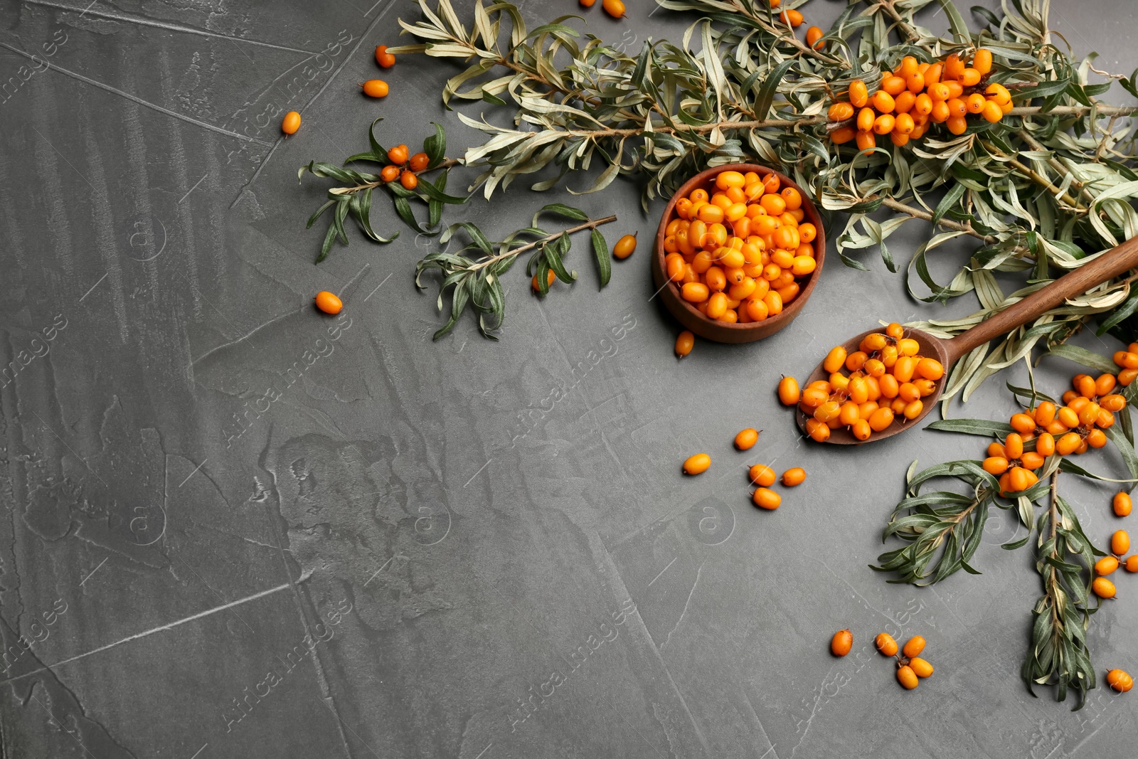 Photo of Fresh ripe sea buckthorn on grey table, flat lay. Space for text