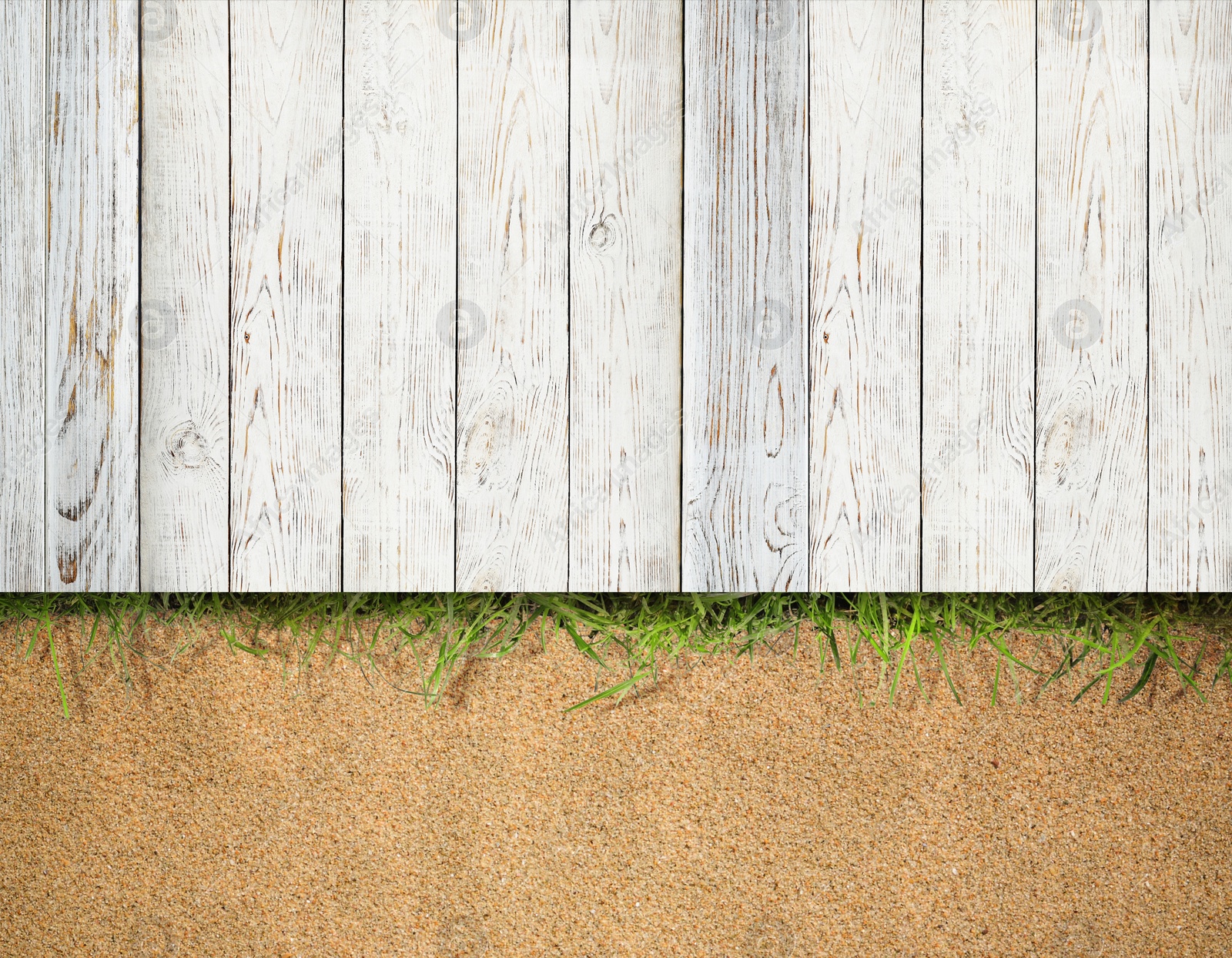 Image of Sand, green grass and white wooden planks outdoors, top view