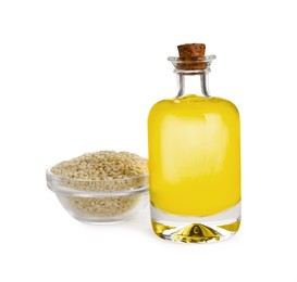 Photo of Glass bottle of fresh sesame oil and bowl with seeds isolated on white