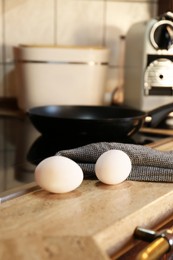 Photo of Fresh eggs on wooden table in kitchen. Ingredient for breakfast