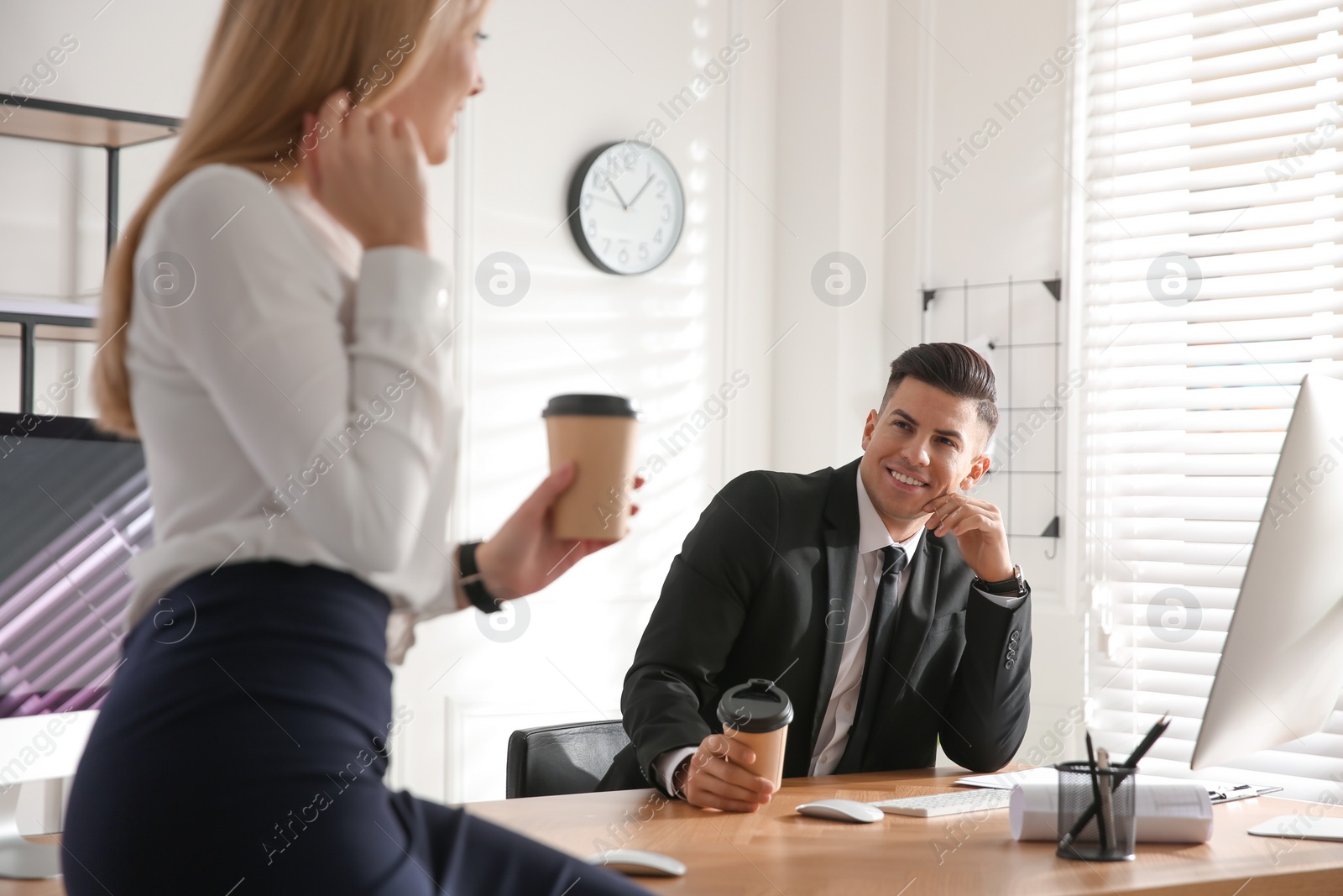 Photo of Man flirting with his colleague during coffee break in office