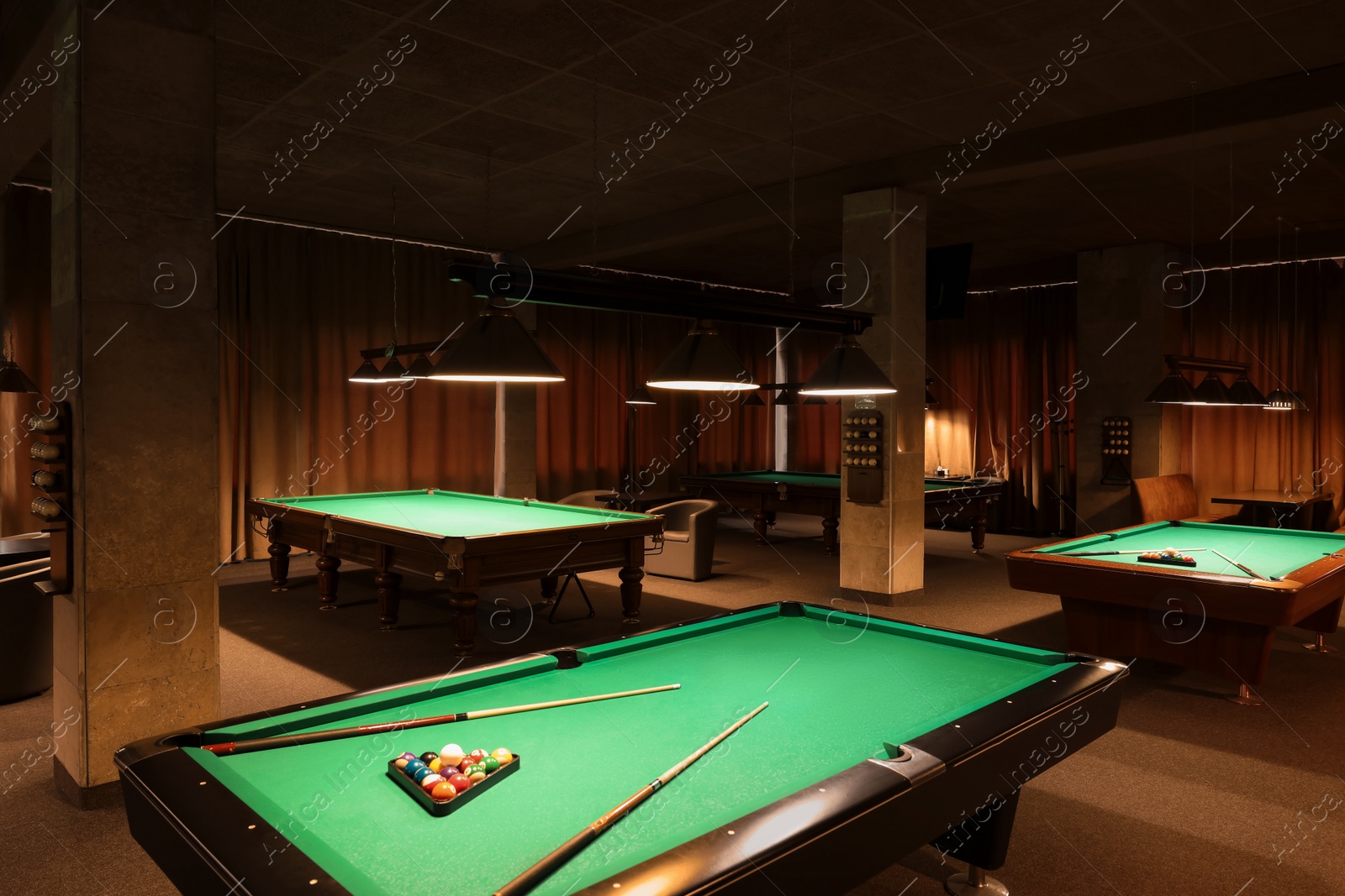 Photo of Billiard tables with balls and cues in club