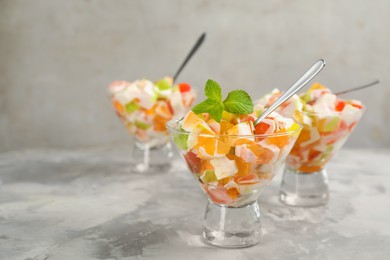 Photo of Delicious broken glass jelly dessert on white marble table, space for text