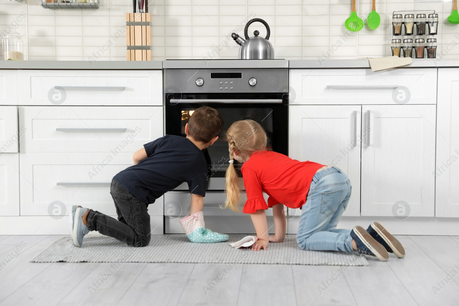 Photo of Little kids baking food in oven at home