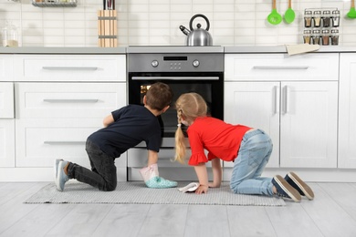 Little kids baking food in oven at home