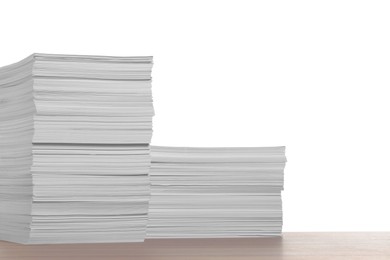 Stacks of paper sheets on wooden table against white background. Space for text