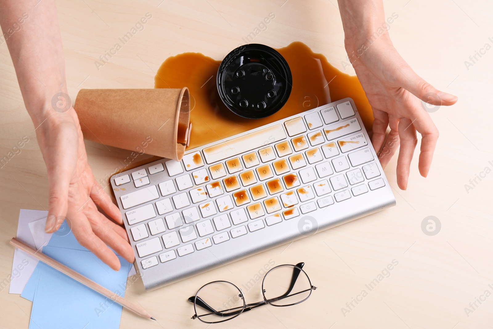 Photo of Woman with coffee spilled over her workplace, closeup