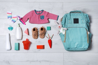 Photo of Flat lay composition with baby accessories and maternity backpack on wooden background