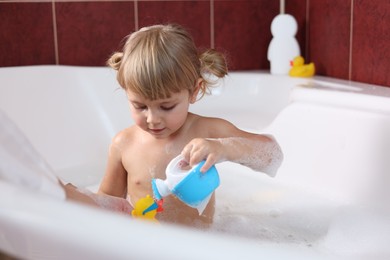 Photo of Mother playing with her little daughter in bathroom, closeup