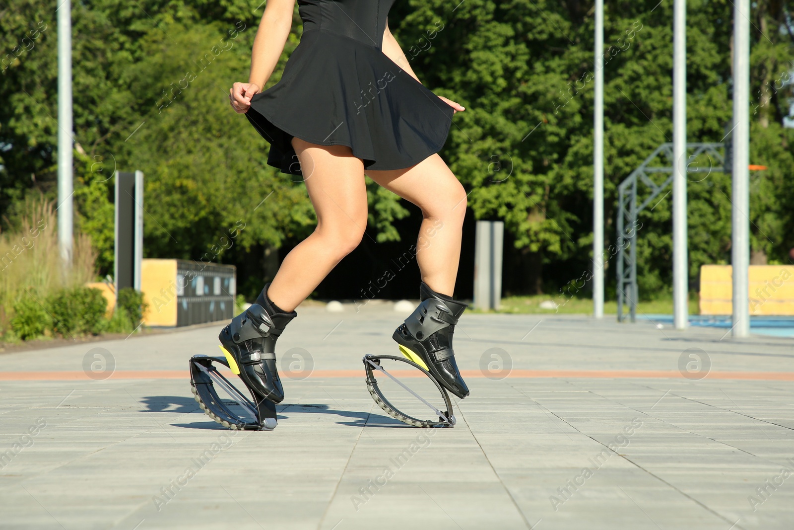 Photo of Woman doing exercises in kangoo jumping boots outdoors, closeup