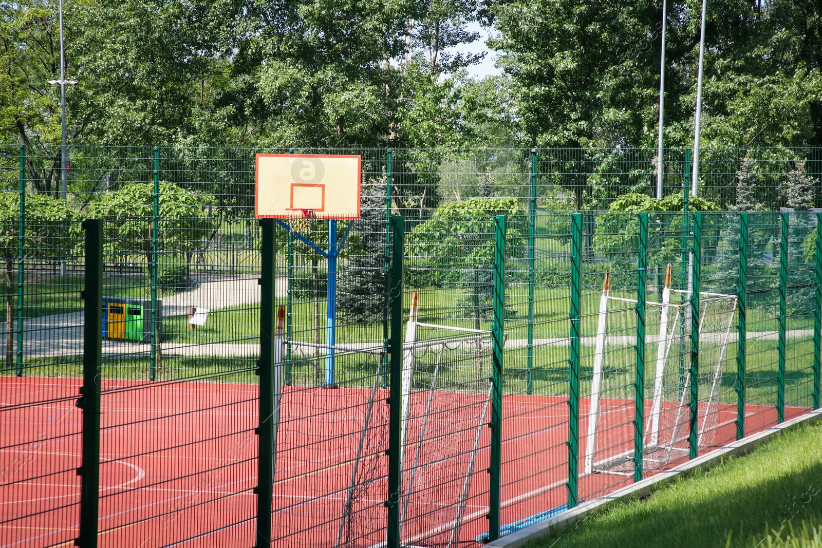 Photo of Multi-sport game court with basketball backboard and football goals on sunny day