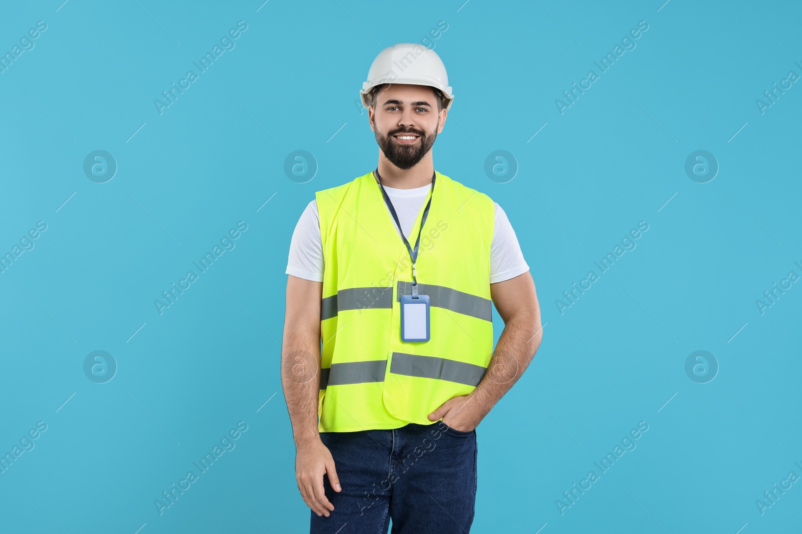 Photo of Engineer with hard hat and badge on light blue background