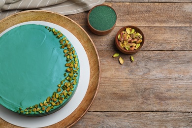 Flat lay composition with spirulina cheesecake on wooden table. Space for text