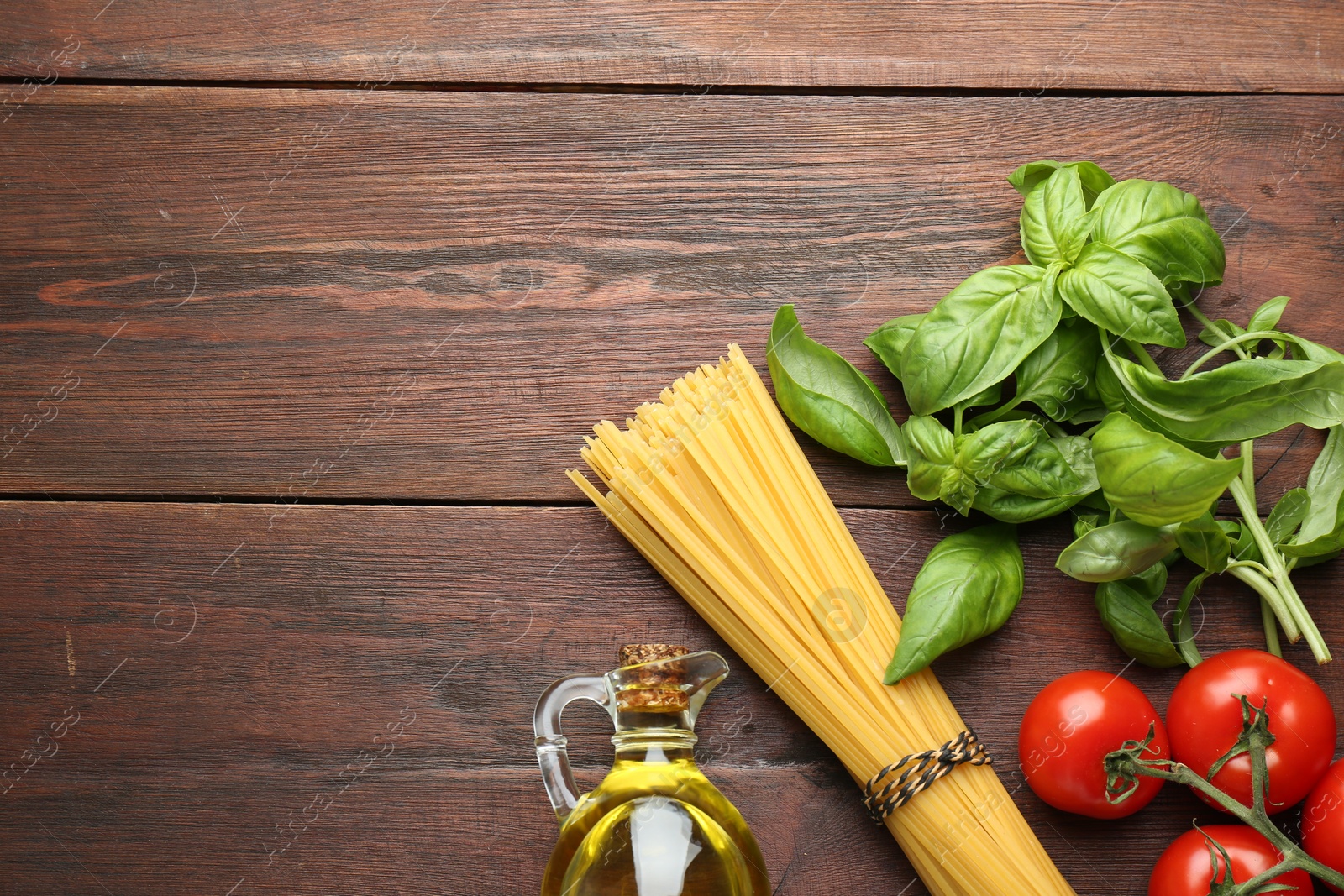 Photo of Raw pasta, spices and products on wooden table, flat lay. Space for text