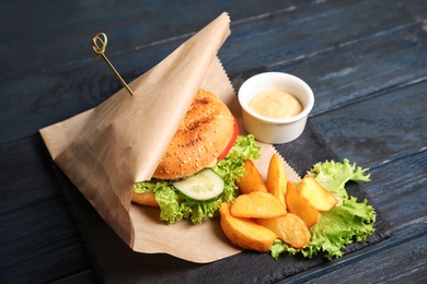 Tasty burger and fries served on slate plate